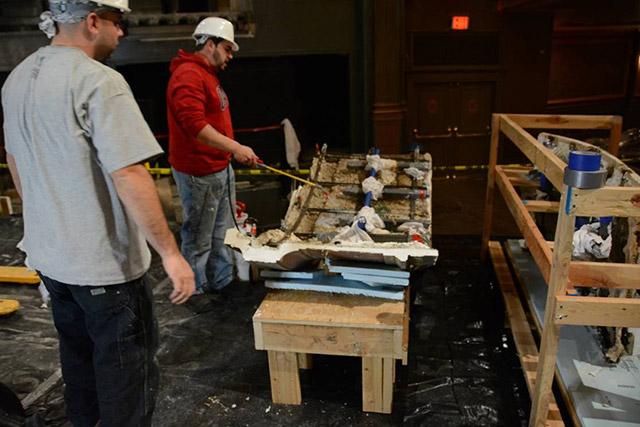 Technicians examining the backside of a cast plaster section prior to reinforcement with RE Aramid Gel